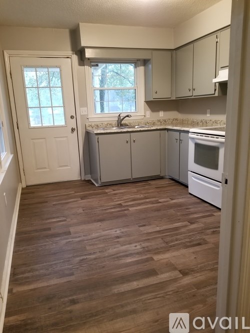 A kitchen with white cabinets and a blue wall.