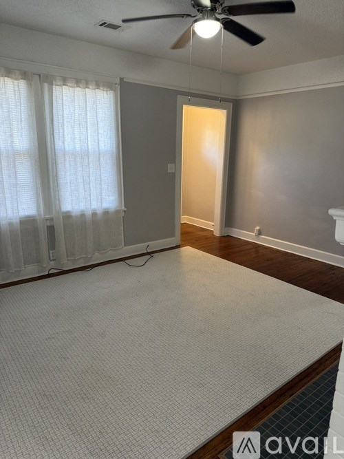 A room with a ceiling fan and a mattress on the floor.