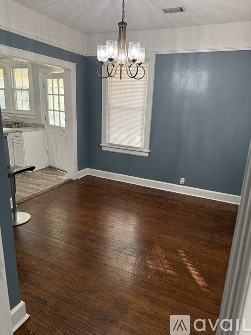 A room with wooden floors and a chandelier.