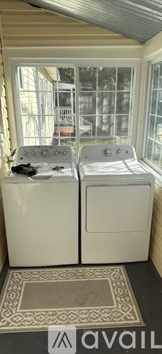 A washing machine and dryer are sitting next to each other in a small room.