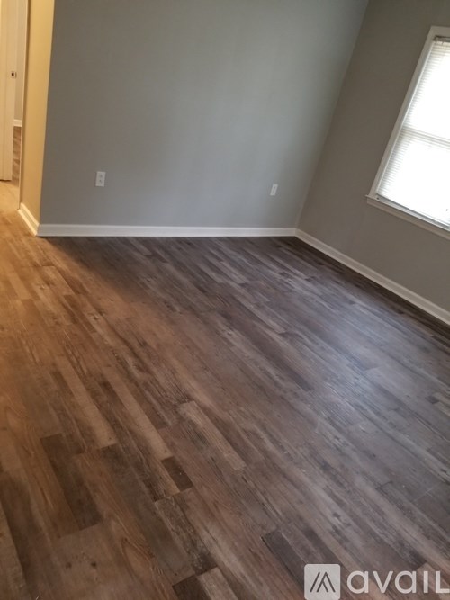 A room with wooden flooring and a window.