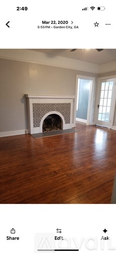 A room with a fireplace and wooden flooring.
