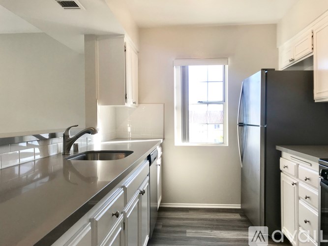 A kitchen with a black fridge and a window.