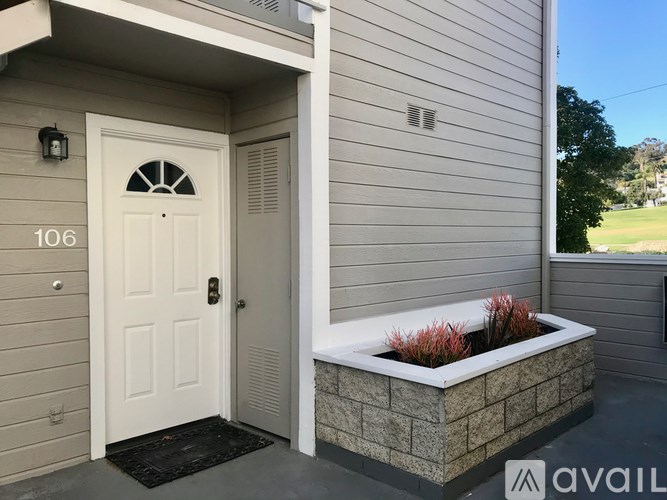 A house numbered 106 has a white door and a planter box outside.