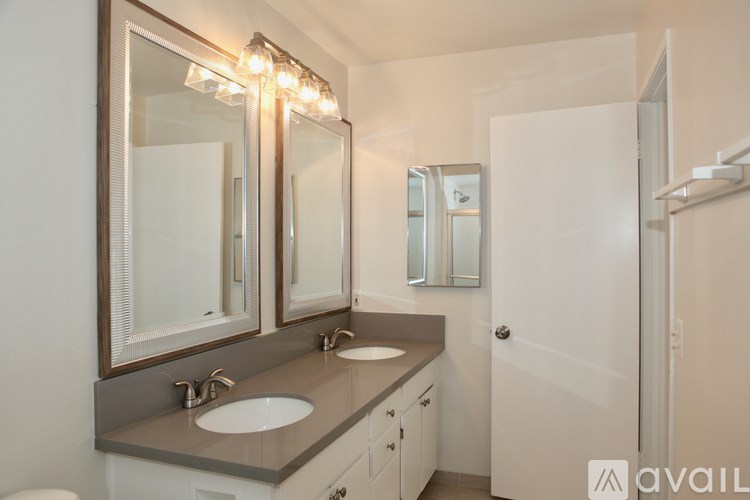 A bathroom with a double sink vanity and a large mirror above it.