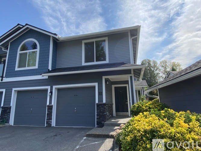 A two-story house with a garage and a front door.