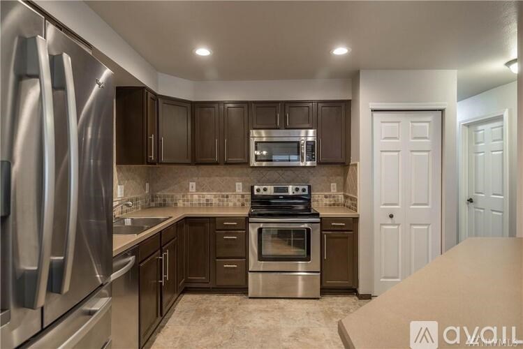 A kitchen with brown cabinets and stainless steel appliances.