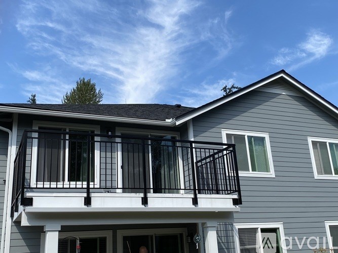 A house with a balcony and a tree on the roof.