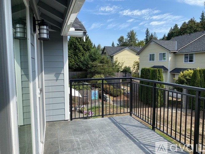 A balcony with a black railing and a view of a residential area.