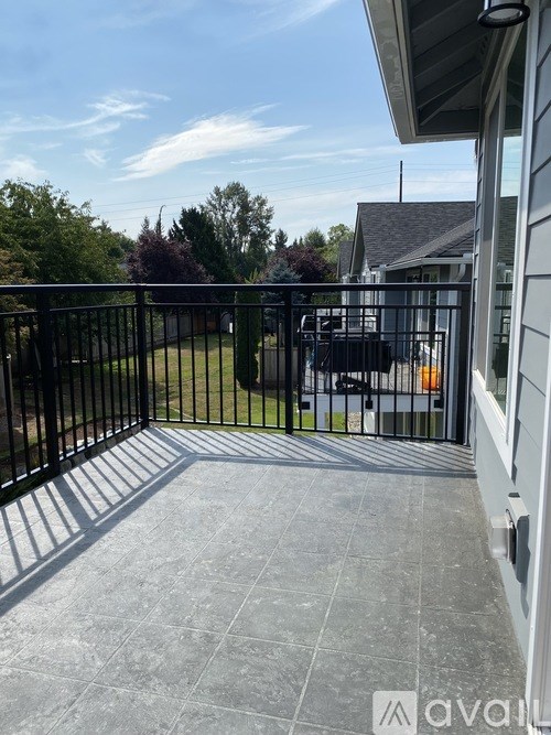A patio with a black railing and a tiled floor.