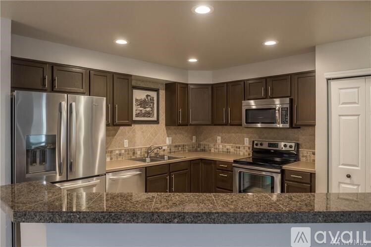 A kitchen with brown cabinets and stainless steel appliances.