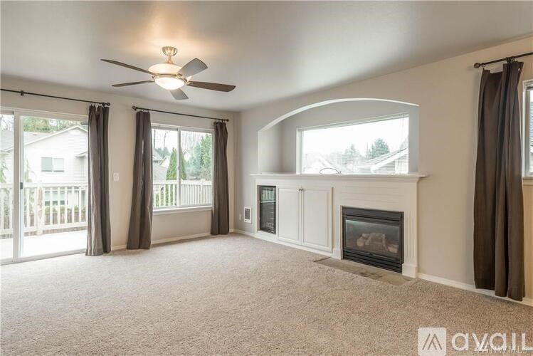 A spacious living room with a fireplace and sliding glass doors.