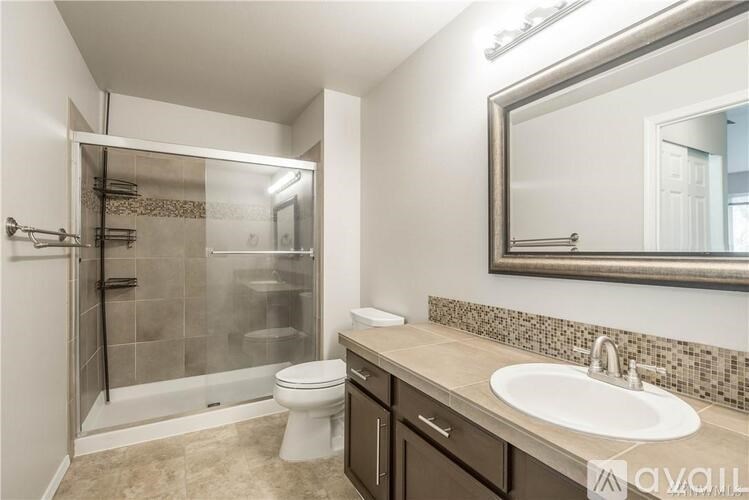 A bathroom with a toilet, sink, and shower.