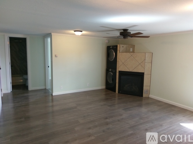 A room with a fireplace and a fan on the ceiling.