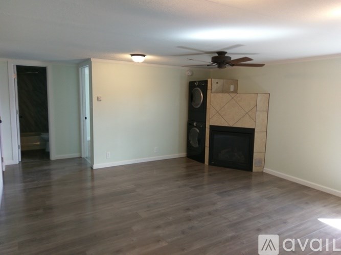 A room with a fireplace and a fan on the ceiling.