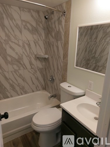 A bathroom with a toilet, sink, and bathtub.