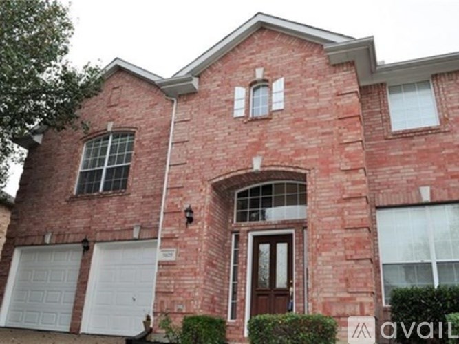 A red brick house with a white garage door.