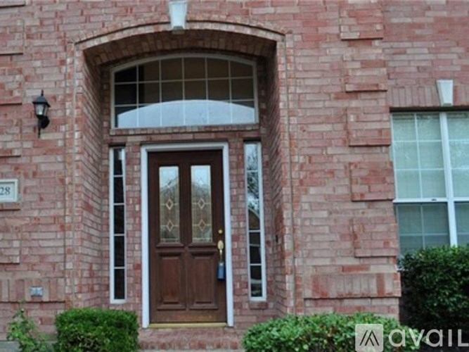 A red brick house with a brown door and a glass window.