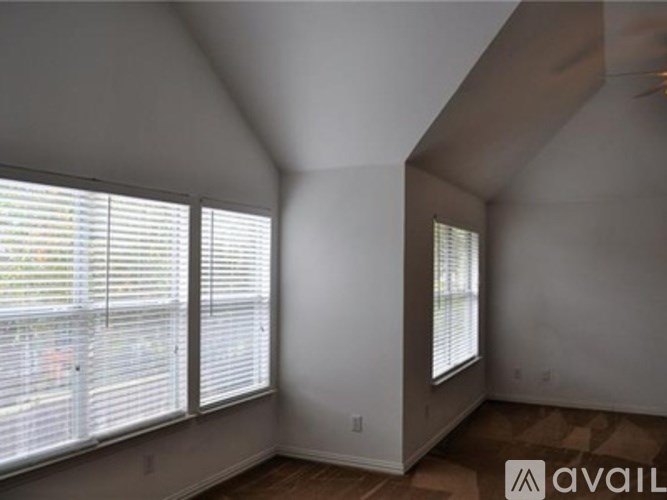 A room with a window and a wooden floor.