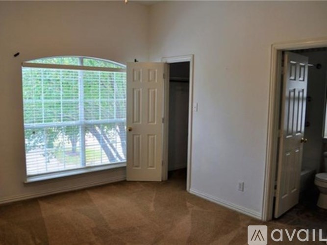 A room with a window, a door, and a toilet.