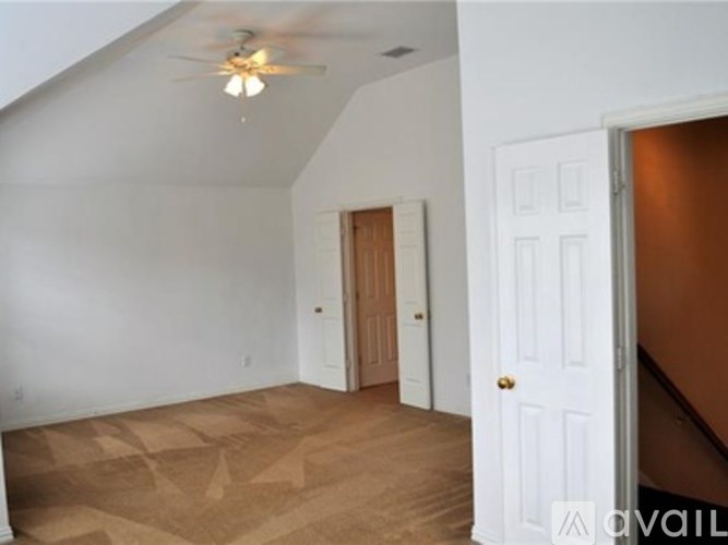 A room with a ceiling fan and two doors.