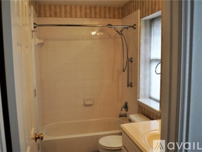 A bathroom with a tub, toilet, and sink.