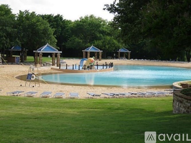 A pool with a slide and sun loungers.