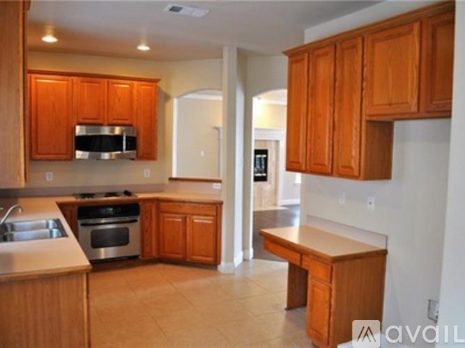 A kitchen with wooden cabinets and a stove top oven.