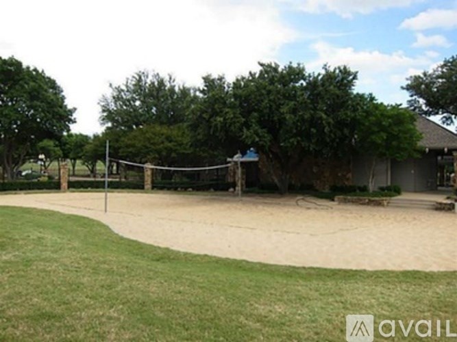 A volleyball net is set up in the middle of a sandy area.