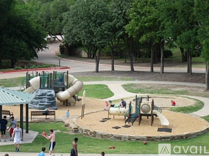 A playground with a slide, sandbox, and children playing.