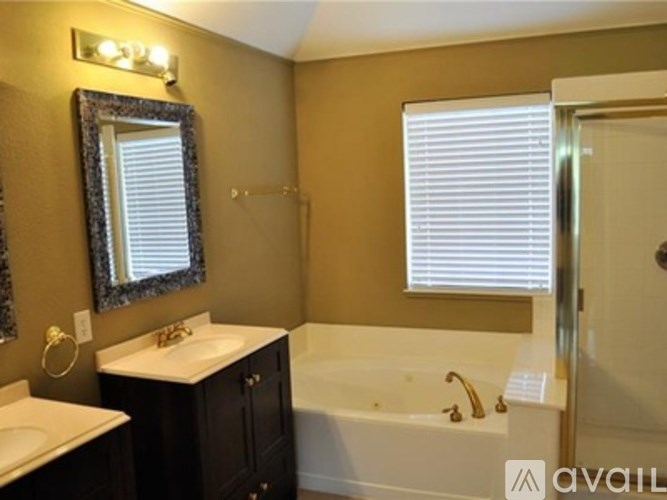A bathroom with a white tub, sink, and mirror.