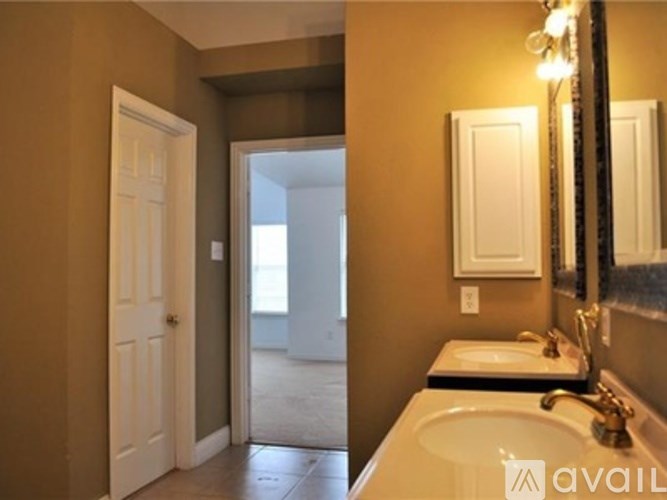 A bathroom with a sink, mirror, and a door.