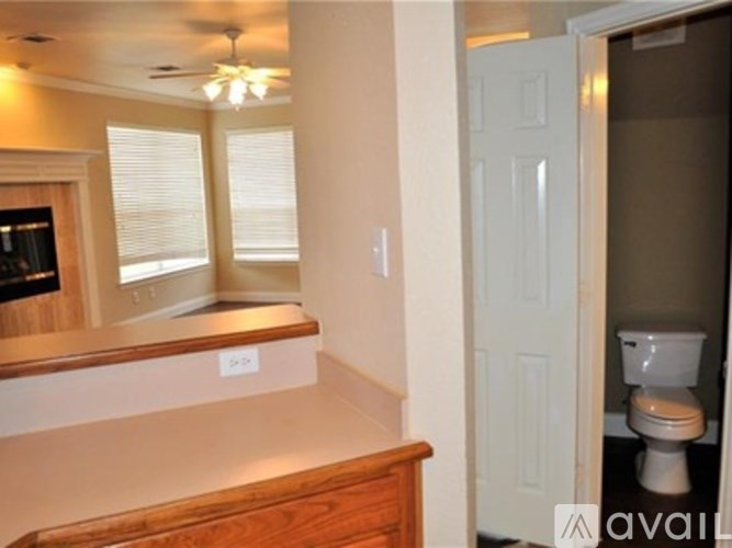 A bathroom with a toilet and a window with blinds.