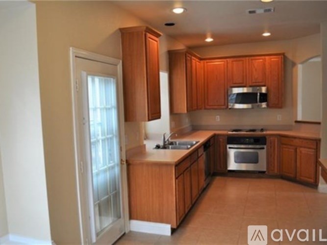 A kitchen with wooden cabinets and a stainless steel oven.