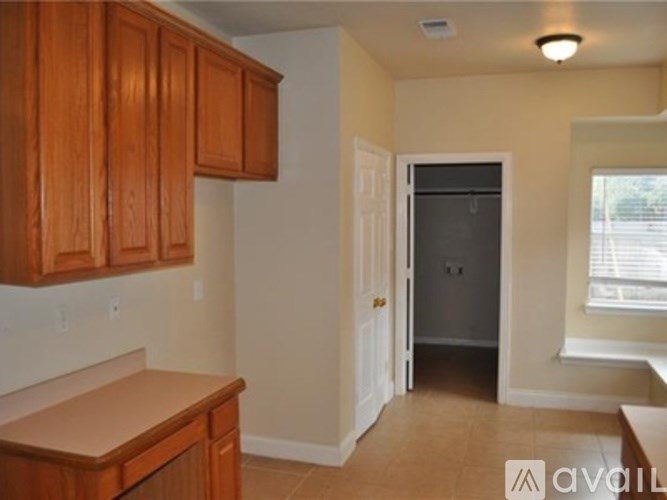 A kitchen with wooden cabinets and a countertop is available for rent.