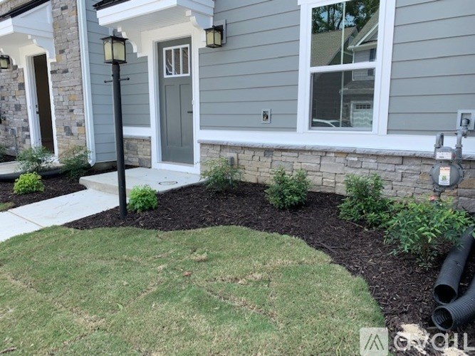 A house with a grey front door and a small garden area.