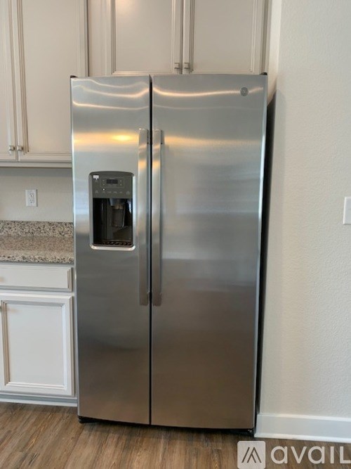A stainless steel refrigerator with a water and ice dispenser in the door.