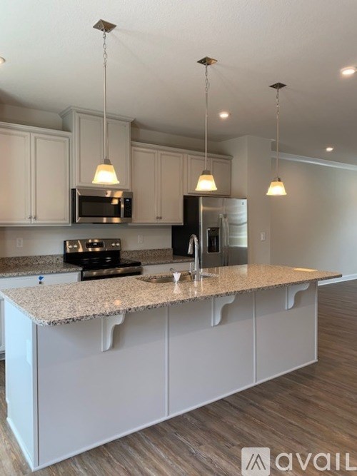 A kitchen with granite countertops and white cabinets.
