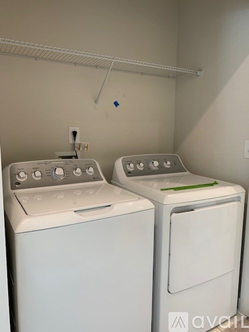 Two white front loading washing machines in a laundry room.