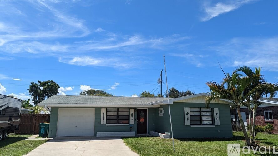 A house with a green exterior and a white garage door.