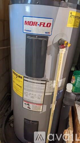 A MOR-FLU water heater with a yellow caution label on it.