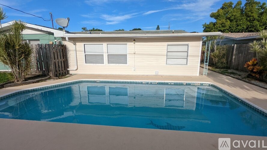A pool in a backyard with a house in the background.