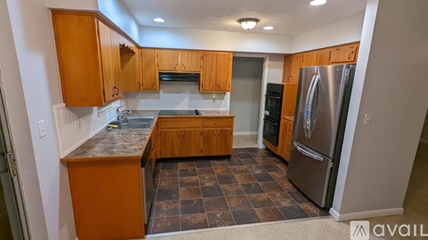 A kitchen with wooden cabinets and a checkered floor.