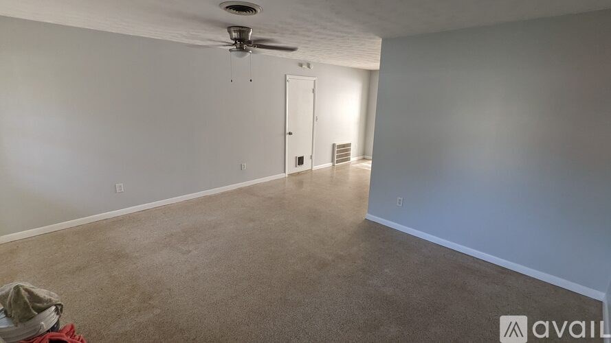 A room with a ceiling fan and carpeted floor.