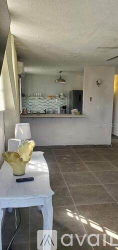 A room with a white table and a yellow bowl on it.