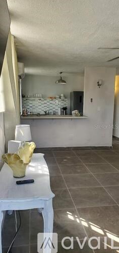 A room with a white table and a yellow bowl on it.