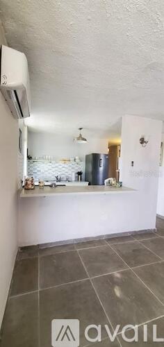 A kitchen with a white counter and a grey floor.