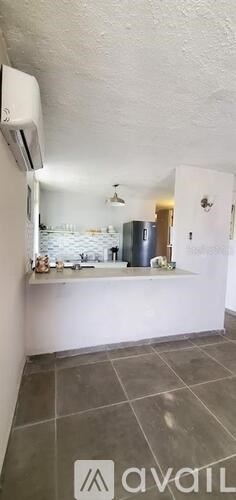 A kitchen with a white counter and a grey floor.