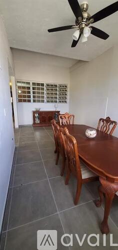 A dining room with a table and chairs.