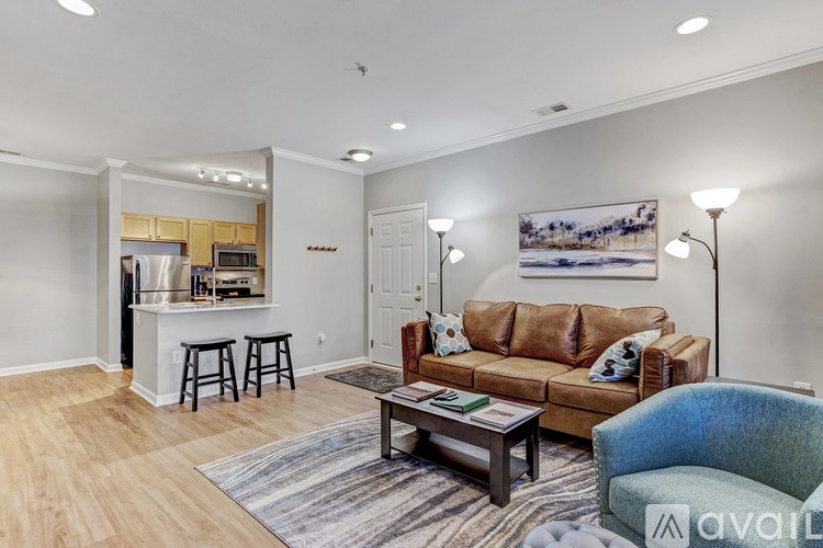 A living room with a couch, a bar, and a painting on the wall.